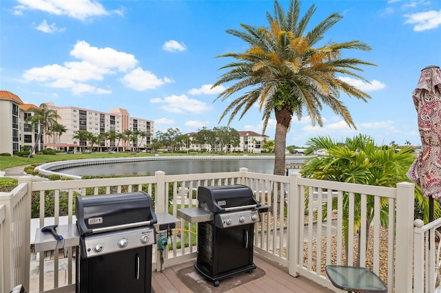 wooden deck with a water view and a grill