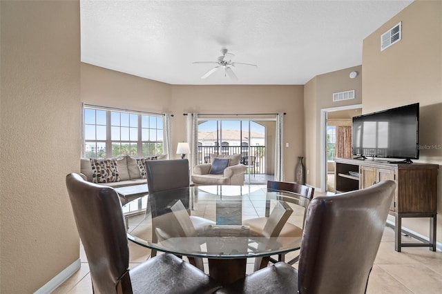 tiled dining room with ceiling fan and a textured ceiling