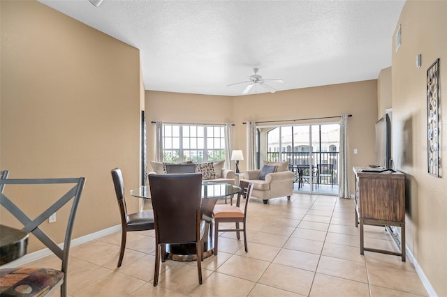 dining area with ceiling fan, light tile patterned floors, and a textured ceiling