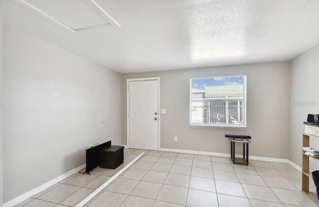 interior space with light tile patterned floors and a textured ceiling