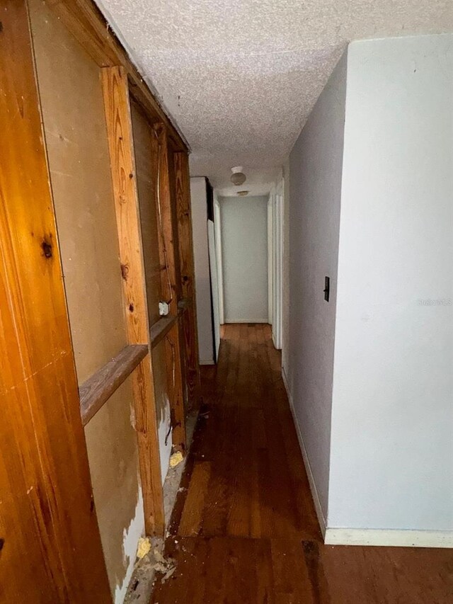 hallway featuring a textured ceiling and dark wood-type flooring