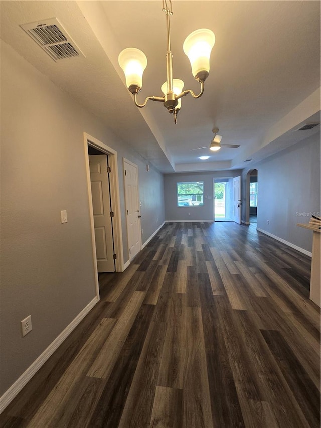 interior space featuring a tray ceiling, dark hardwood / wood-style flooring, and a chandelier