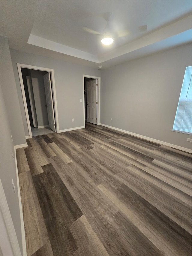 unfurnished room featuring dark hardwood / wood-style floors and a raised ceiling