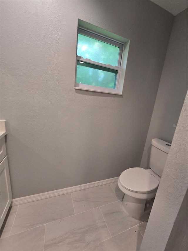 bathroom with vanity, tile patterned flooring, and toilet