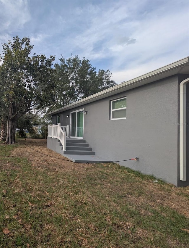 view of property exterior featuring a yard and stucco siding