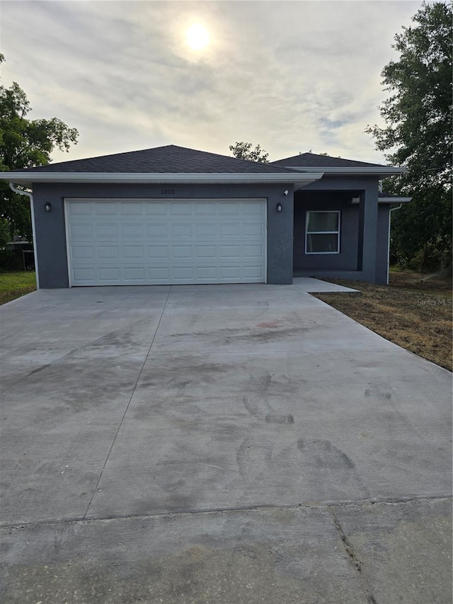 ranch-style house with stucco siding, an attached garage, and concrete driveway