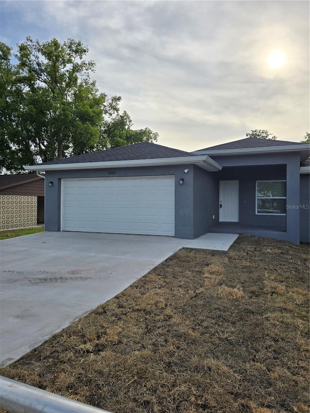single story home featuring stucco siding, driveway, and a garage