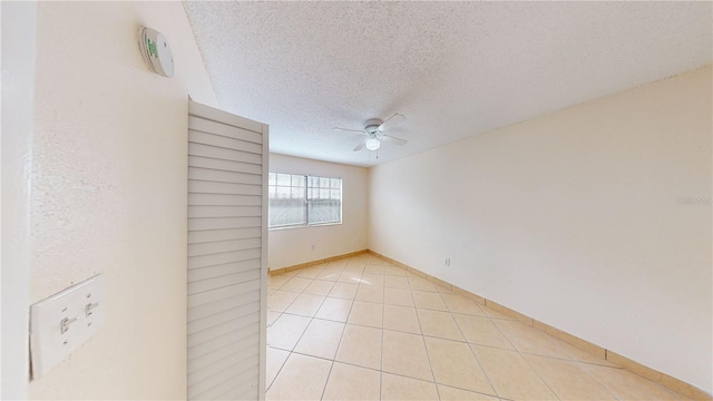 unfurnished room with light tile patterned floors, a textured ceiling, and ceiling fan