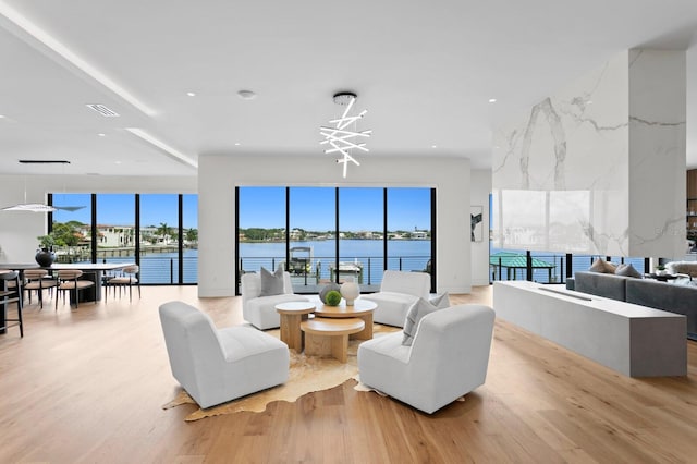 living room with a water view and light wood-type flooring