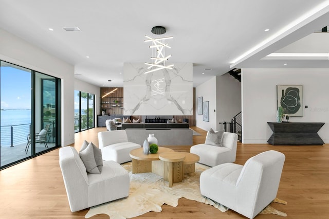 living room with a water view and light hardwood / wood-style floors