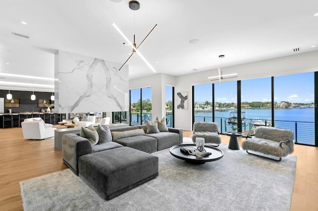 living room featuring a water view and light wood-type flooring