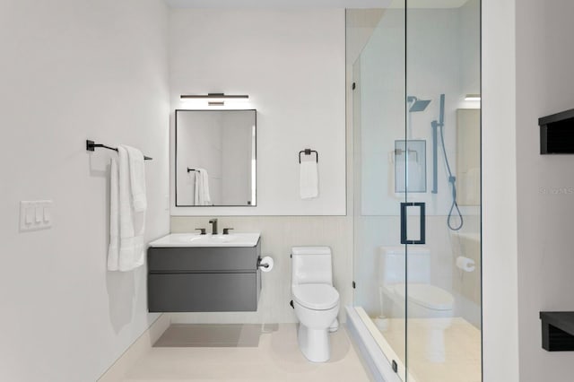 bathroom with vanity, toilet, and a shower with shower door