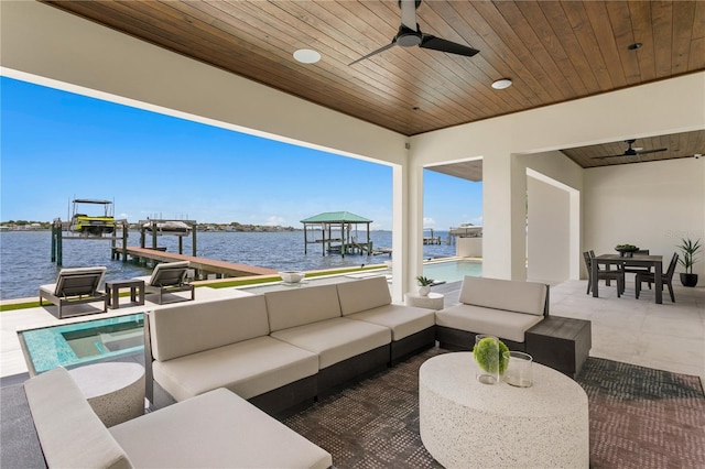 view of patio / terrace with outdoor lounge area, ceiling fan, a water view, and a dock