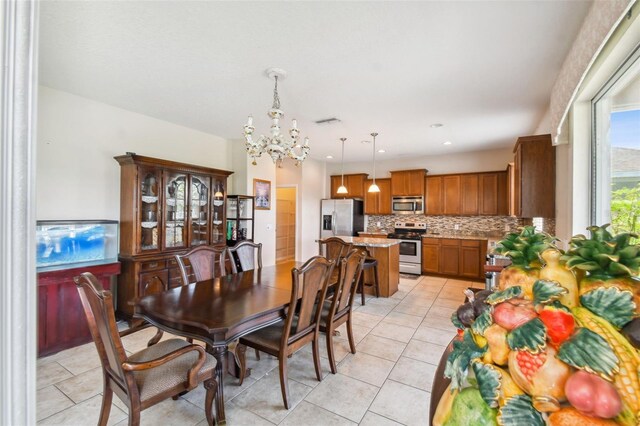 tiled dining room featuring a notable chandelier