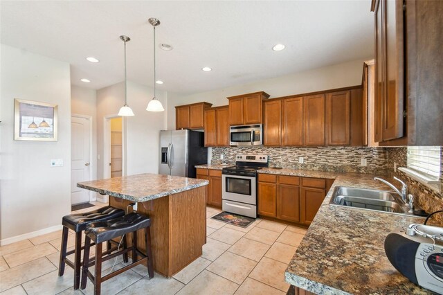 kitchen featuring pendant lighting, a center island, a kitchen breakfast bar, sink, and appliances with stainless steel finishes