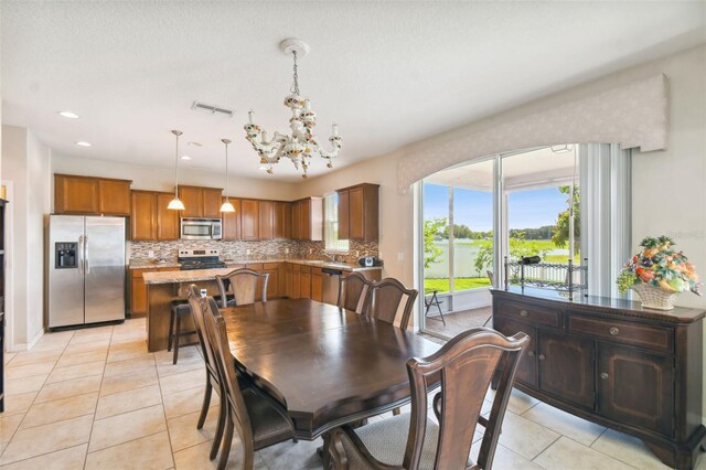 dining room with light tile patterned floors and an inviting chandelier