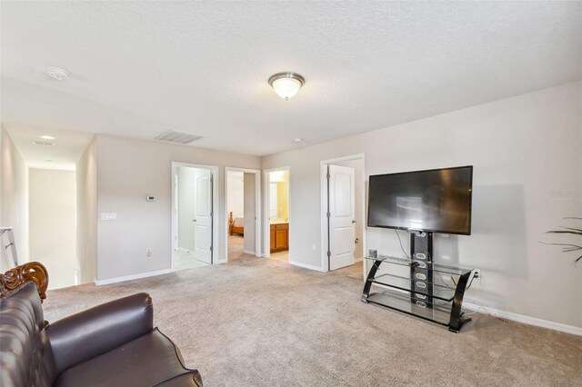 living room featuring light carpet and a textured ceiling