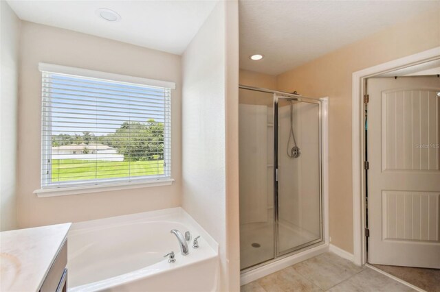 bathroom with tile patterned flooring, vanity, and plus walk in shower