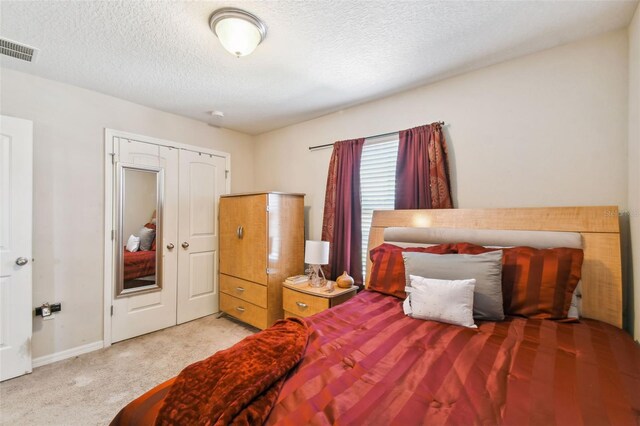 carpeted bedroom featuring a closet and a textured ceiling