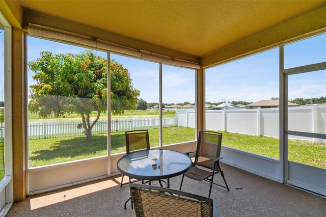 sunroom / solarium featuring a water view