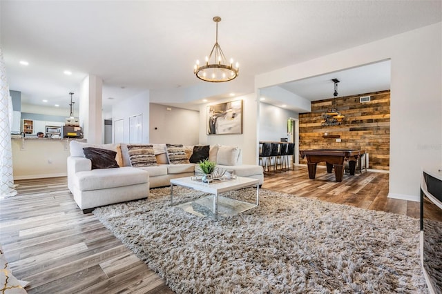 living room featuring wood walls, light wood-type flooring, and pool table