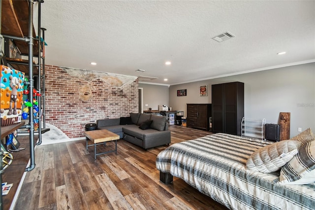 living room featuring hardwood / wood-style floors, ornamental molding, brick wall, and a textured ceiling