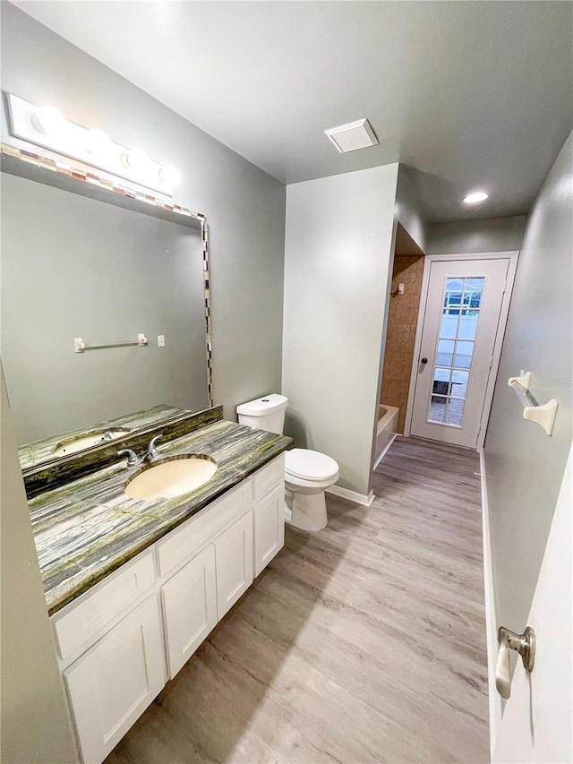 full bathroom featuring  shower combination, hardwood / wood-style flooring, vanity, and toilet