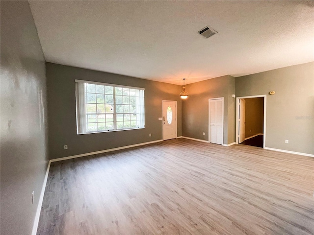 spare room featuring a textured ceiling and hardwood / wood-style floors