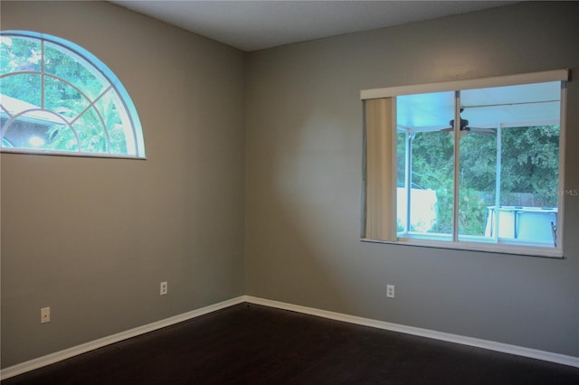 unfurnished room with dark hardwood / wood-style floors and a wealth of natural light