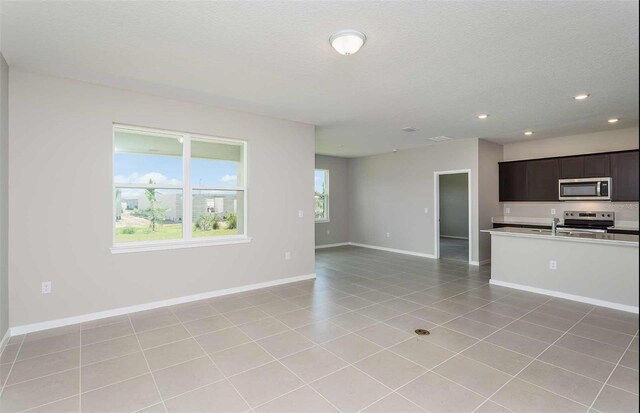 8322 SW 52nd Lane Rd, Ocala, FL 34481 - unfurnished living room with baseboards, recessed lighting, a textured ceiling, and light tile patterned floors
