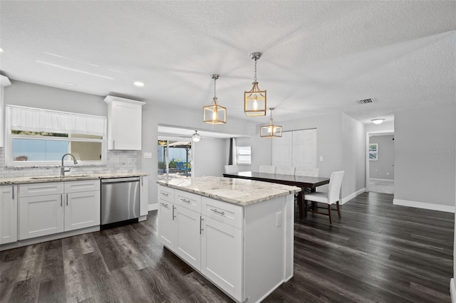 kitchen featuring pendant lighting, dishwasher, backsplash, white cabinets, and sink