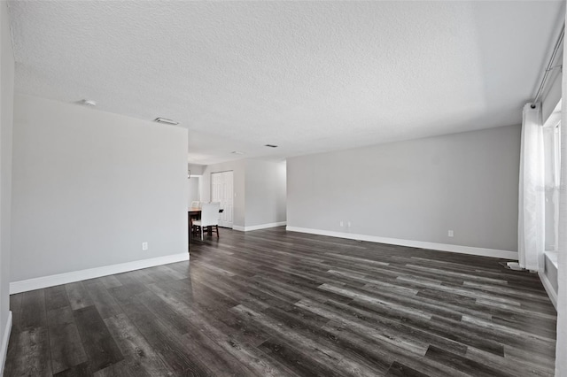 unfurnished living room featuring dark hardwood / wood-style flooring and a textured ceiling