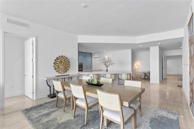 dining area featuring baseboards, light wood finished floors, visible vents, and recessed lighting