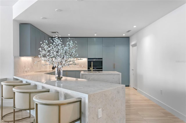 kitchen with tasteful backsplash, recessed lighting, oven, a peninsula, and baseboards