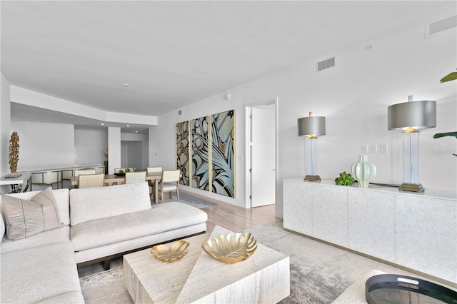 living room with light wood-style floors and visible vents