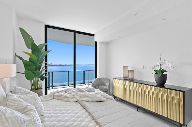 bedroom with a water view, access to exterior, and expansive windows