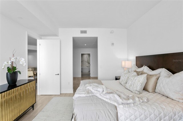 bedroom with light wood-style flooring and visible vents