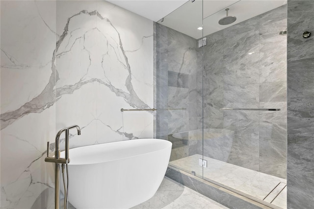 bathroom with marble finish floor, a marble finish shower, and stone wall