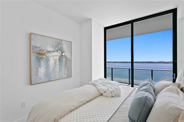 bedroom with a water view and floor to ceiling windows