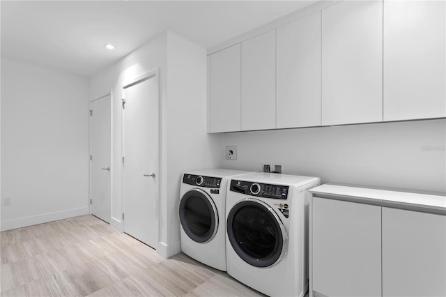 laundry room with baseboards, cabinet space, and washing machine and clothes dryer