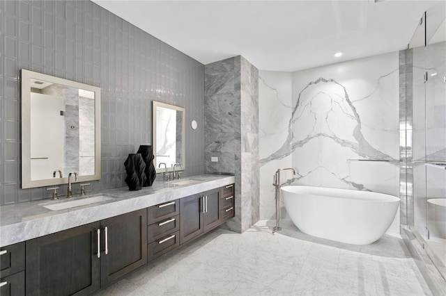 bathroom with a soaking tub, a sink, tile walls, and double vanity