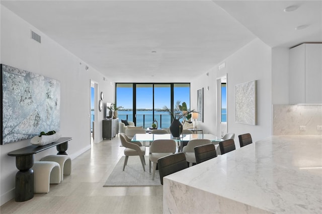 dining area with a water view and expansive windows