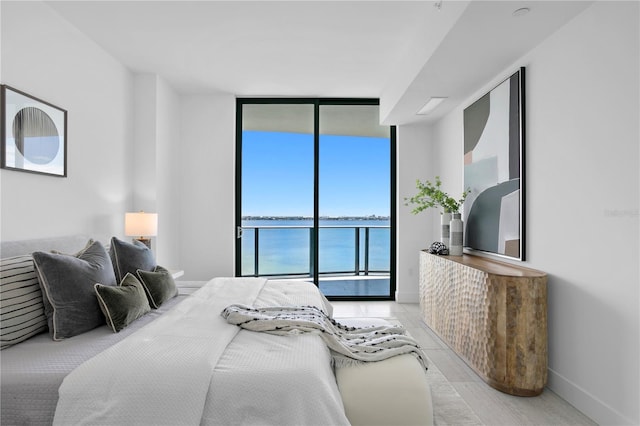 bedroom featuring light hardwood / wood-style flooring and a water view