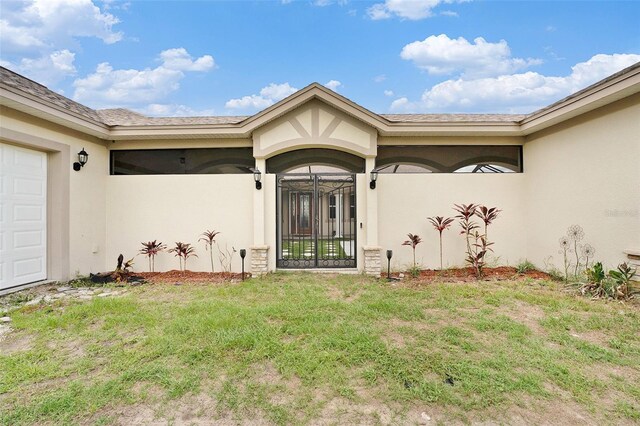 property entrance featuring a garage and a yard