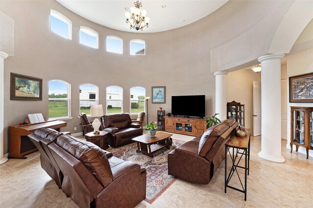 living room with a high ceiling, a notable chandelier, and light tile patterned floors