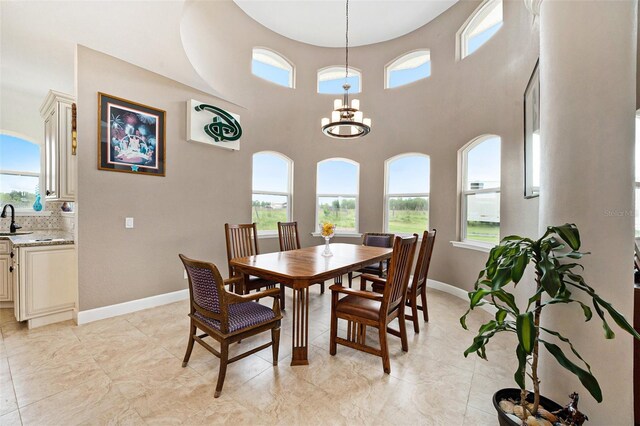 tiled dining area with a towering ceiling and a notable chandelier