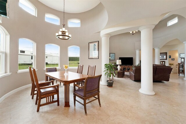 tiled dining area featuring an inviting chandelier, a wealth of natural light, and a high ceiling