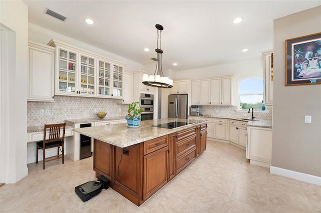 kitchen with stainless steel appliances, sink, decorative light fixtures, a kitchen island, and decorative backsplash