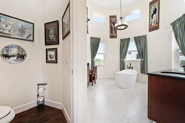 bathroom with vanity, a chandelier, hardwood / wood-style flooring, and toilet