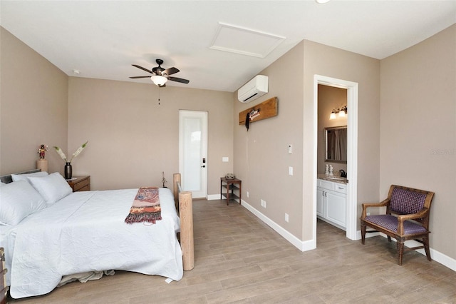 bedroom featuring light hardwood / wood-style floors, ensuite bathroom, a wall mounted AC, and ceiling fan